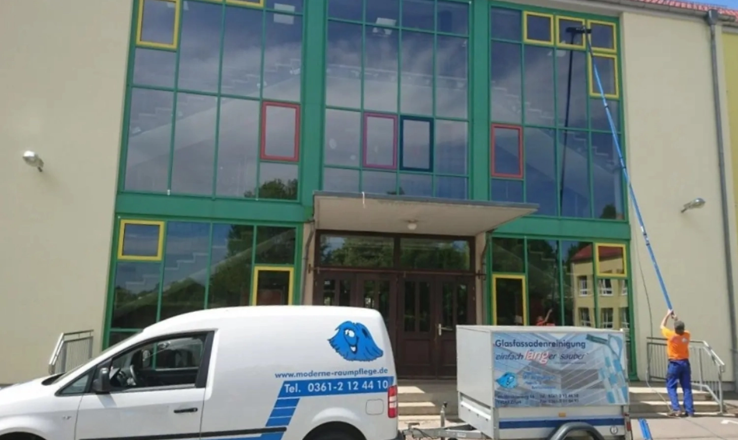 Moderne Raumpflege GmbH Boge – Gebäudereinigung – ein Arbeiter reinigt die Glasfenster eines Hochhauses, daneben ein Firmenfahrzeug.